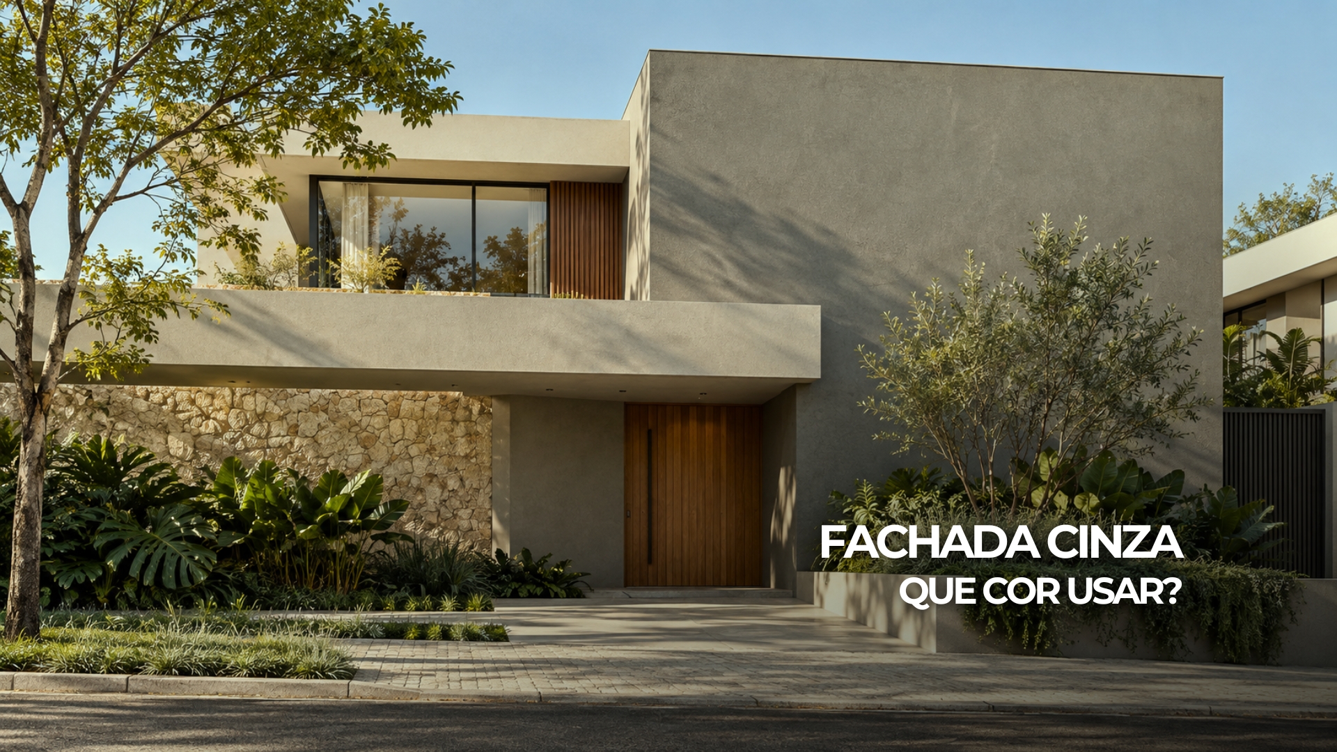 Fachada cinza e areia com porta de madeira, esquadrias escuras e vegetação discreta.